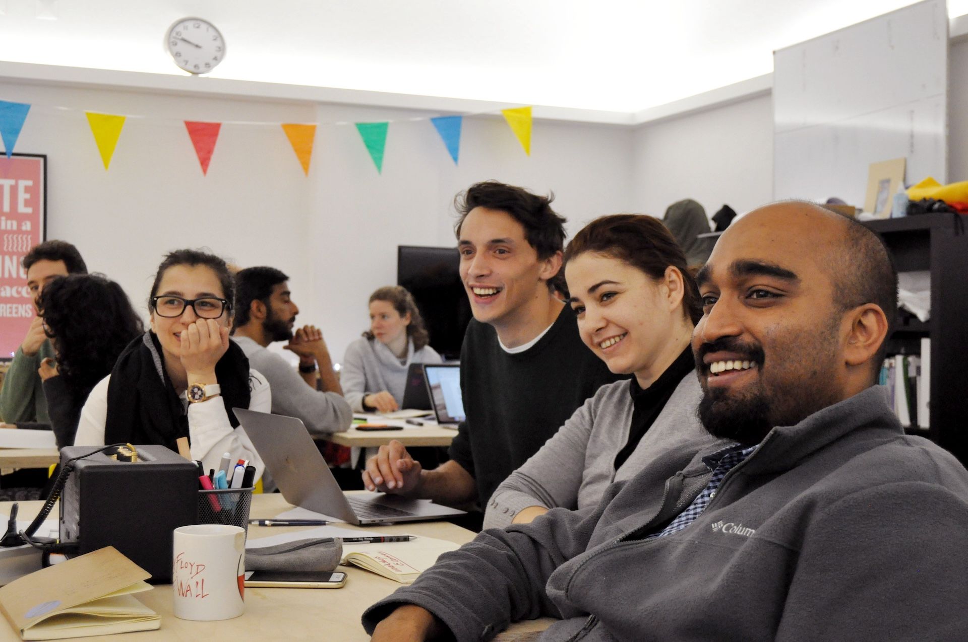 Students and teachers laughing together in the school's studio in Porto.
