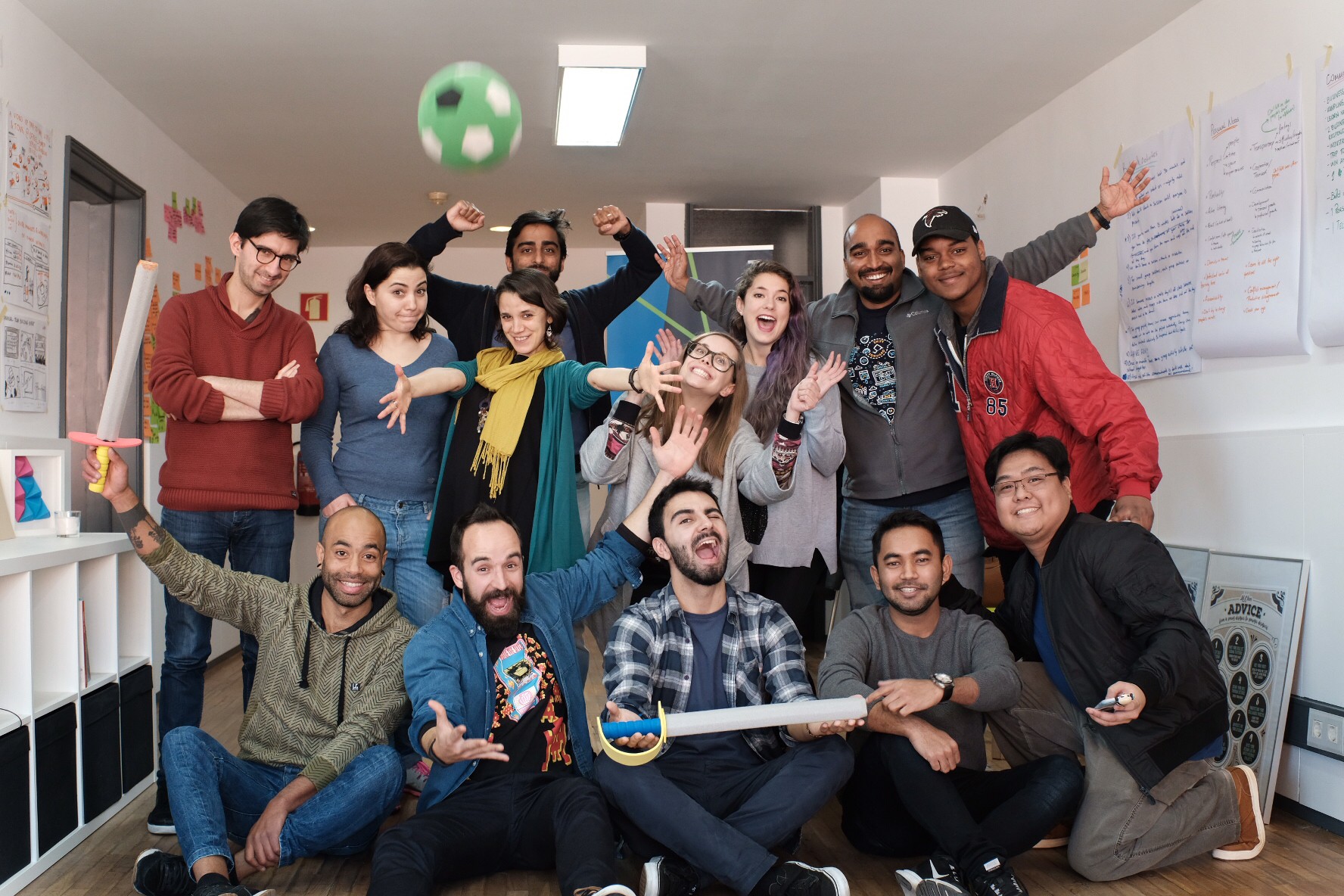 The class and guest Edite Amorim pull faces for a group photo, with a ball mid-air and foam swords